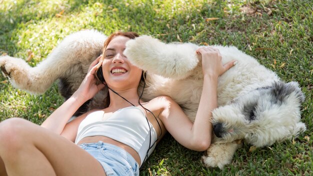 Femme avec chien en plein air écoute de la musique