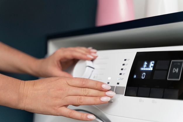 Femme choisissant un programme pour la machine à laver