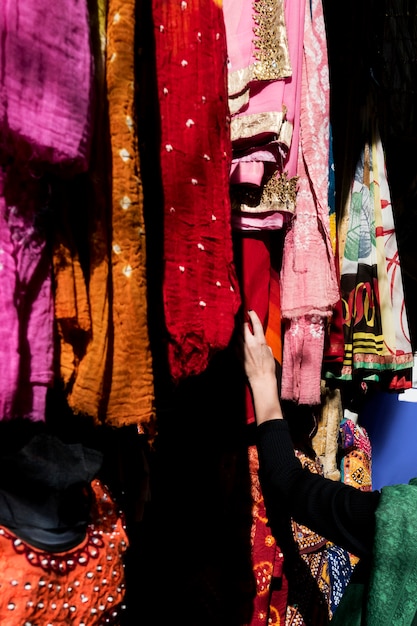 Femme choisissant un sari coloré sur le marché