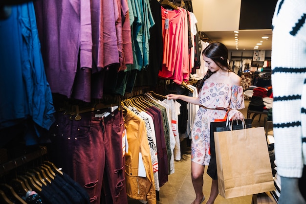 Femme choisissant des vêtements dans la boutique