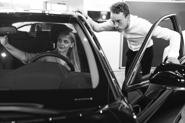 Femme choisissant une voiture dans une salle d'exposition