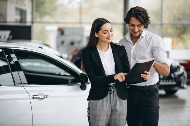 Femme choisissant une voiture dans une salle d'exposition