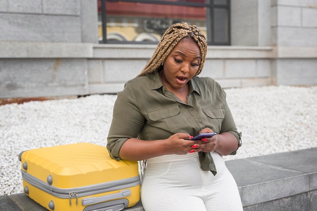 Photo gratuite femme à la choqué lors du défilement sur une application de médias sociaux à l'extérieur