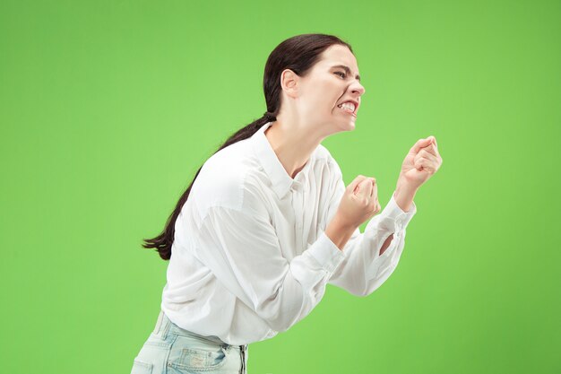 Femme en colère regardant la caméra. Femme d'affaires agressive debout isolée sur un espace vert branché