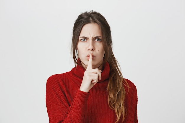 Photo gratuite femme en colère shushing avec le doigt pressé sur les lèvres