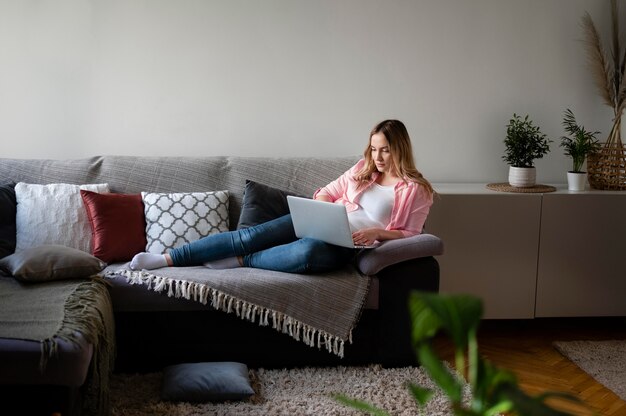 Femme complète travaillant avec un ordinateur portable