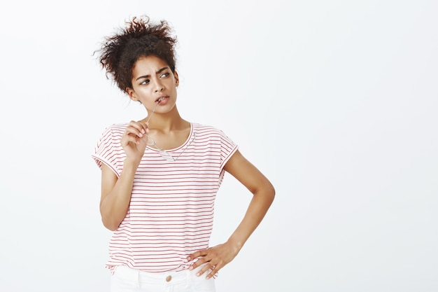 Photo gratuite femme concentrée avec une coiffure afro posant en studio