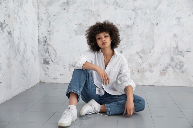 Femme confiante aux cheveux bouclés posant