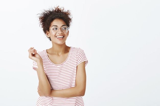 Photo gratuite femme confiante avec une coiffure afro qui pose en studio