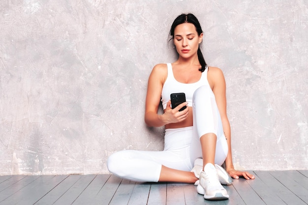 Femme confiante de remise en forme en vêtements de sport Sexy jeune beau modèle avec un corps parfait Femme posant en studio S'étirant avant l'entraînement