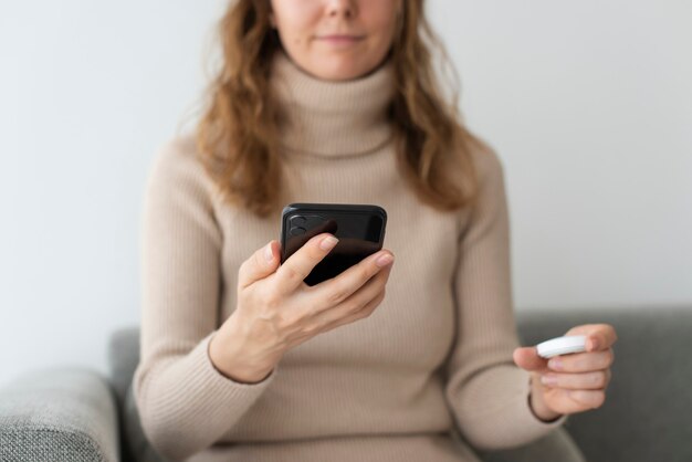 Femme connectant le haut-parleur intelligent au téléphone