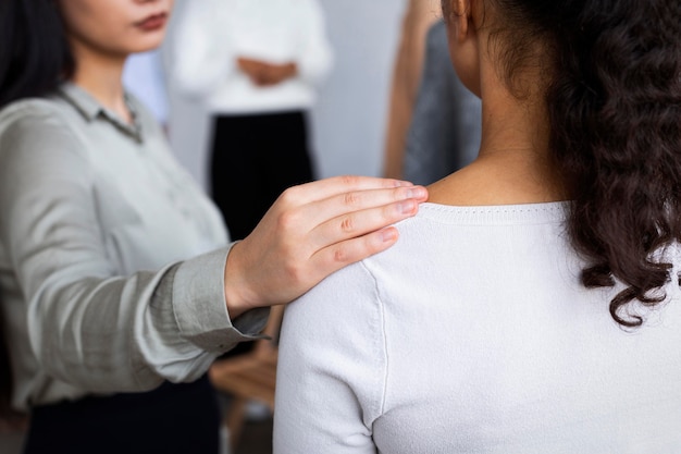 Femme consoler la personne lors d'une séance de thérapie de groupe