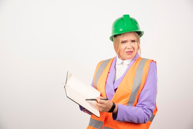 Femme constructeur en casque avec tablette sur fond blanc. Photo de haute qualité