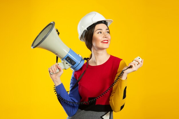 Femme, construction, casque, haut-parleur, mains