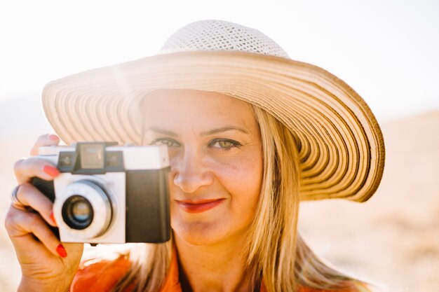 Femme de contenu avec appareil photo vintage au soleil