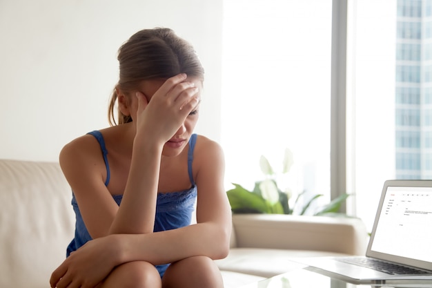 Femme contrariée par de mauvaises nouvelles dans une lettre électronique