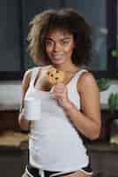 Photo gratuite femme avec cookie dans la cuisine