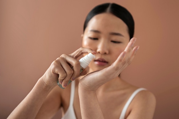 Femme coréenne à coup moyen posant avec du sérum