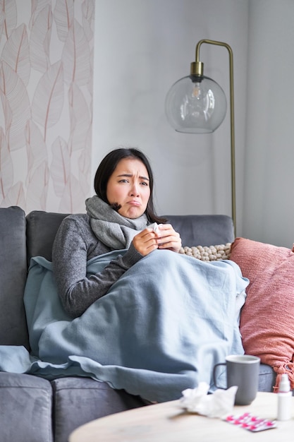 Photo gratuite une femme coréenne se sent mal en éternuant et en toussant attrapant un rhume en restant à la maison avec de la fièvre et de la température en prenant des médicaments
