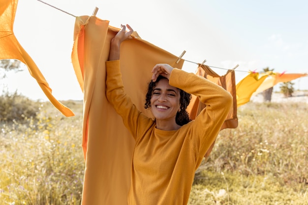 Femme à côté de la corde à linge dans les champs