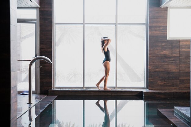 Femme à côté de la piscine au spa