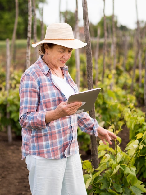 Femme de côté vérifiant son jardin