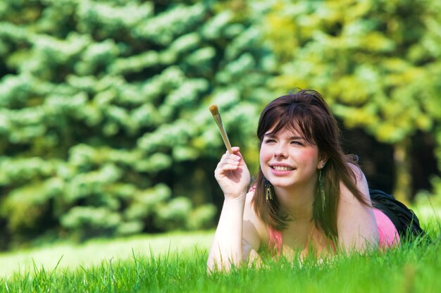 Femme couchée sur l&#39;herbe avec un pinceau