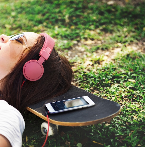 Photo gratuite femme, coucher herbe, écouter musique