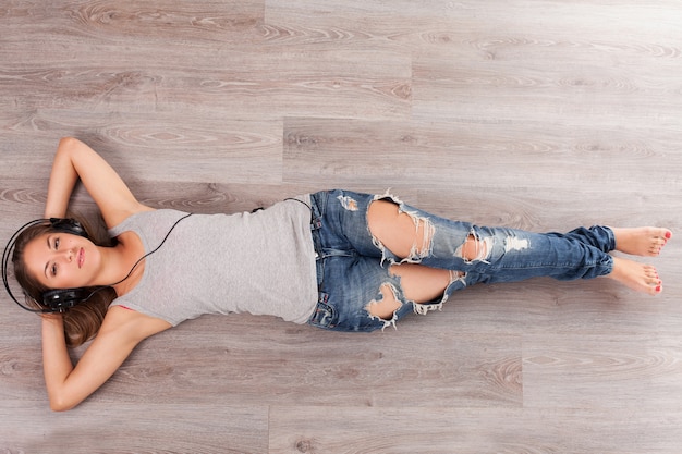 Femme, coucher plancher, à, écouteurs