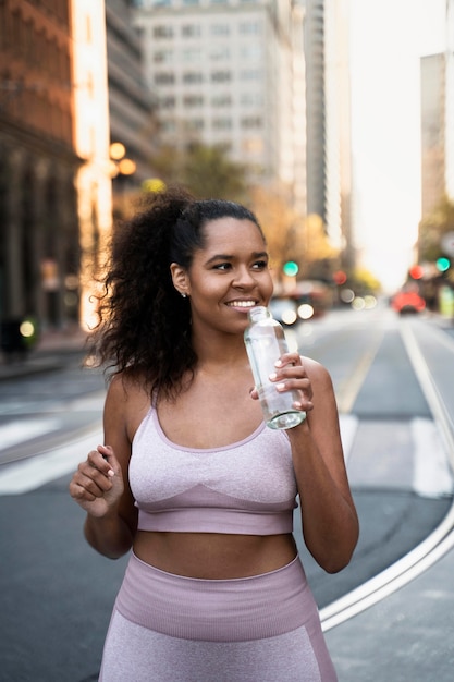 Photo gratuite femme de coup moyen avec une bouteille d'eau