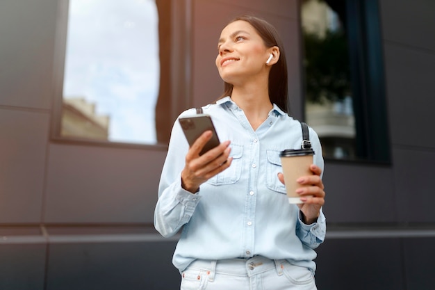 Femme de coup moyen avec café et téléphone