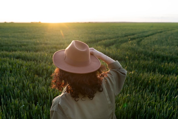 Femme de coup moyen avec un chapeau dans la nature