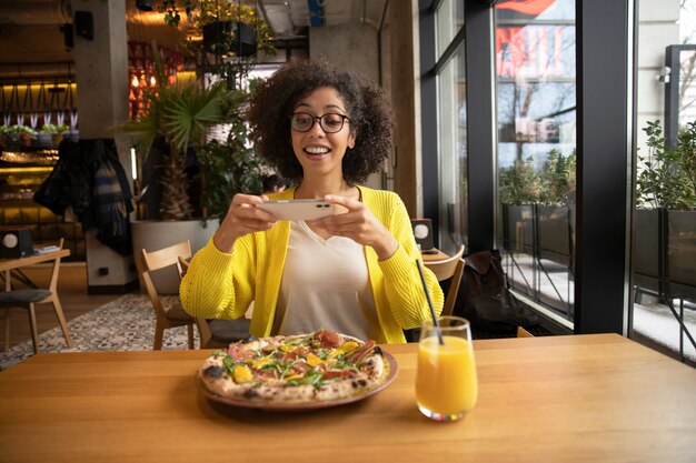 Femme de coup moyen avec une délicieuse pizza