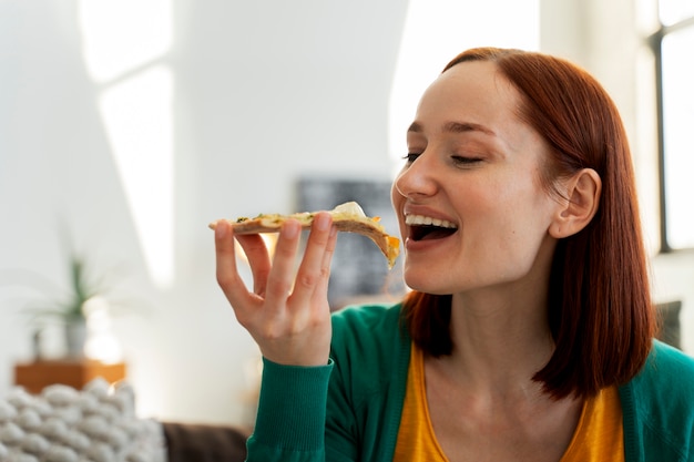 Photo gratuite femme de coup moyen avec une délicieuse pizza