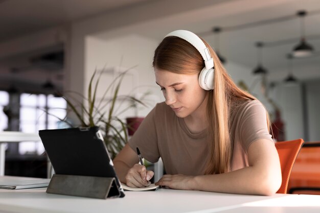 Femme de coup moyen écrivant des informations