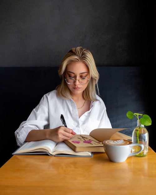 Photo gratuite femme à coup moyen avec journal et livre