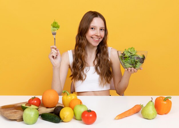 Femme de coup moyen avec des légumes