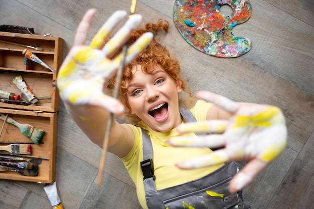 Femme de coup moyen avec de la peinture sur les mains