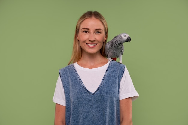 Photo gratuite femme à coup moyen avec perroquet en studio