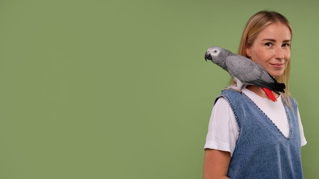 Femme à coup moyen avec perroquet en studio