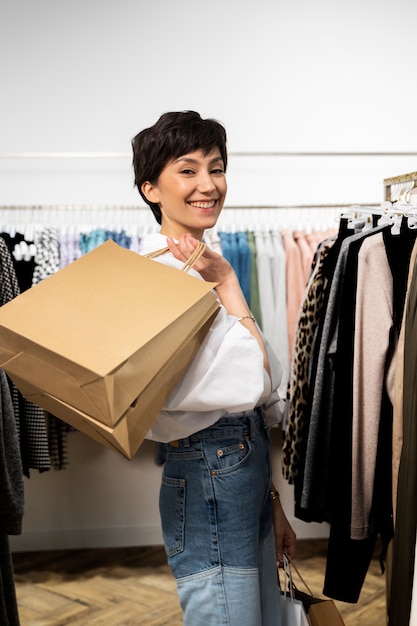 Femme de coup moyen avec des sacs à provisions