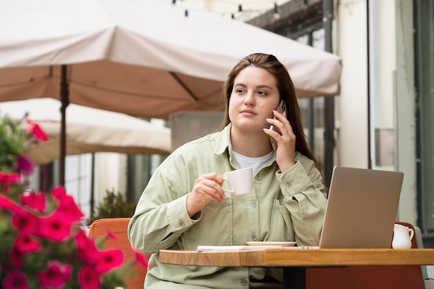 Femme de coup moyen à la terrasse