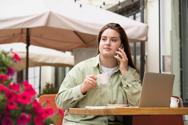 Femme de coup moyen à la terrasse