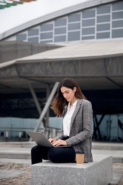 Femme de coup moyen travaillant avec un ordinateur portable