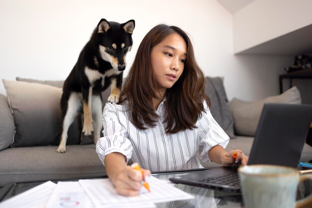 Femme de coup moyen travaillant avec un ordinateur portable