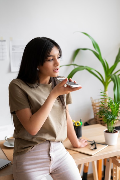 Femme de coup moyen travaillant avec un téléphone