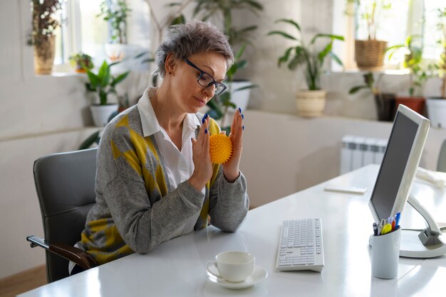 Femme à coup moyen utilisant une balle pour s'étirer