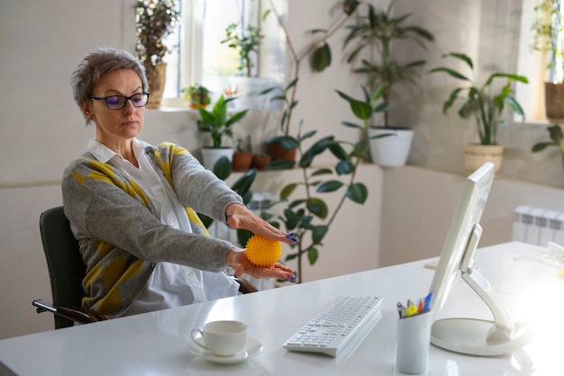 Femme à coup moyen utilisant une balle pour s'étirer