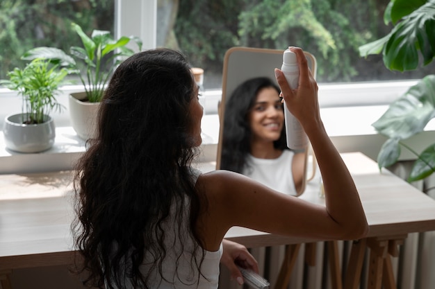 Femme à coup moyen utilisant du shampoing sec à la maison