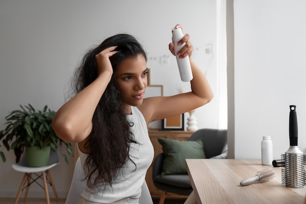 Photo gratuite femme à coup moyen utilisant du shampoing sec à la maison
